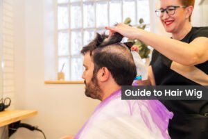 Side view of a friendly hairdresser removing carefully the capillary prosthesis to a client