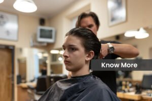 Long-haired teenager sitting on a hairdressing chair at a men's hairdressing salon in a retro hairdressing salon and barber shop. Growing a child into a man.